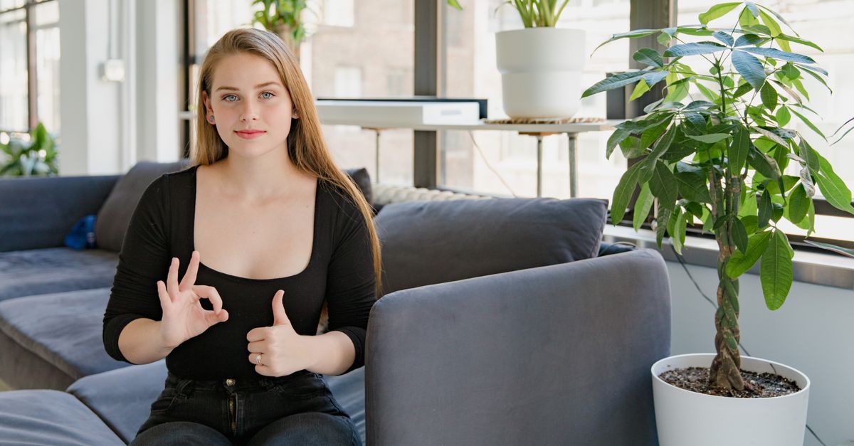 Sitting Young Woman Using Sign Language · Free Stock Photo