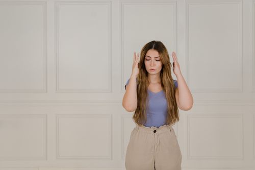 Free Young woman signing with eyes closed, expressing communication through sign language. Stock Photo