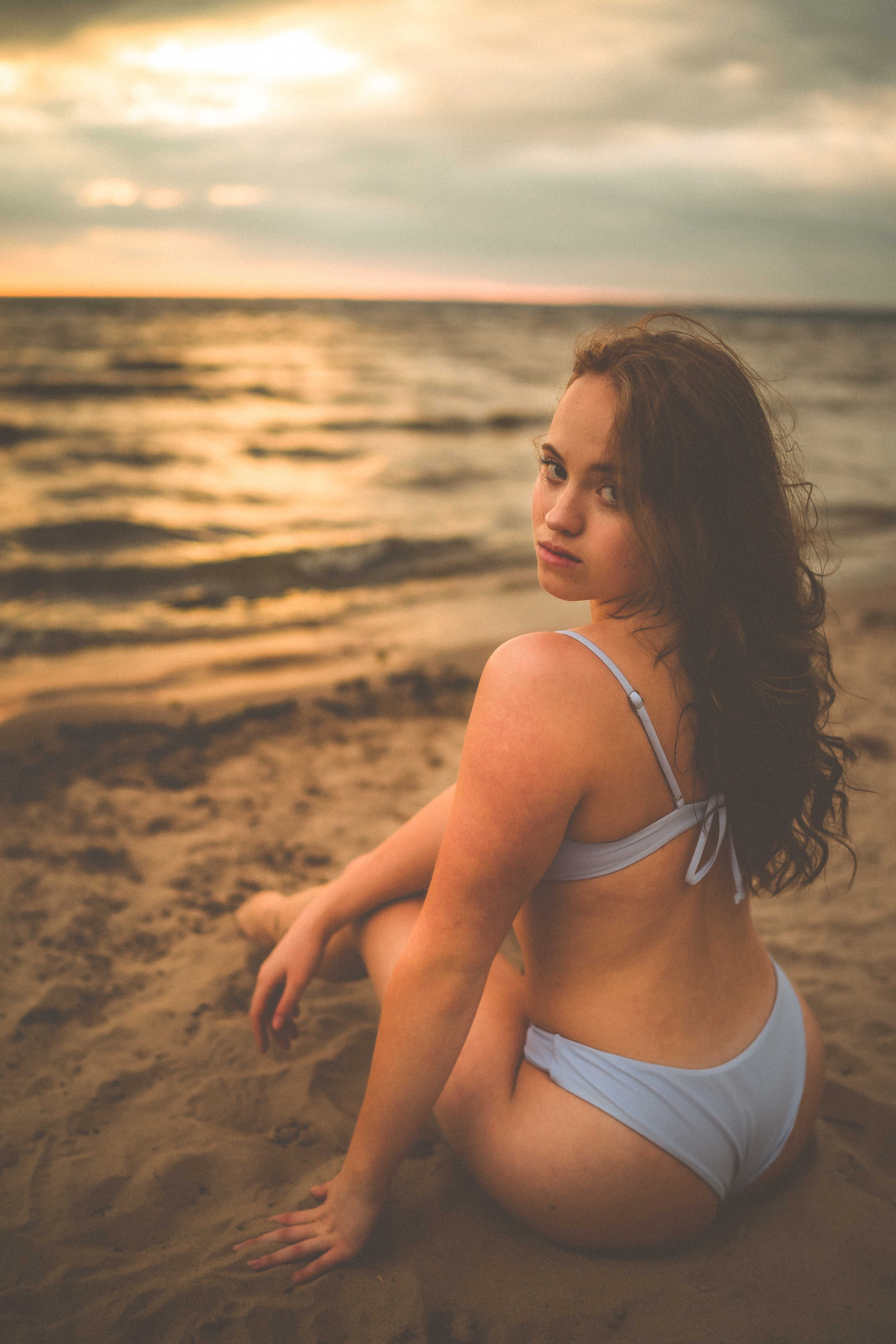 Woman in Blue Bikini Sitting on Sand · Free Stock Photo