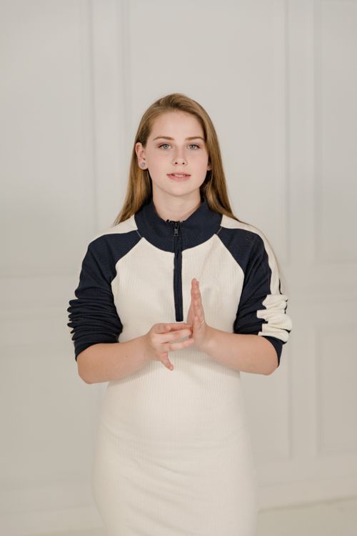 Free A woman using sign language to communicate, standing indoors, signifying inclusivity and communication. Stock Photo