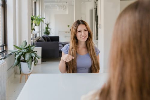 Free Two women using sign language in a modern indoor setting, promoting deaf community communication. Stock Photo