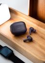 Black Wireless Bluetooth Earbuds on Brown Wooden Table