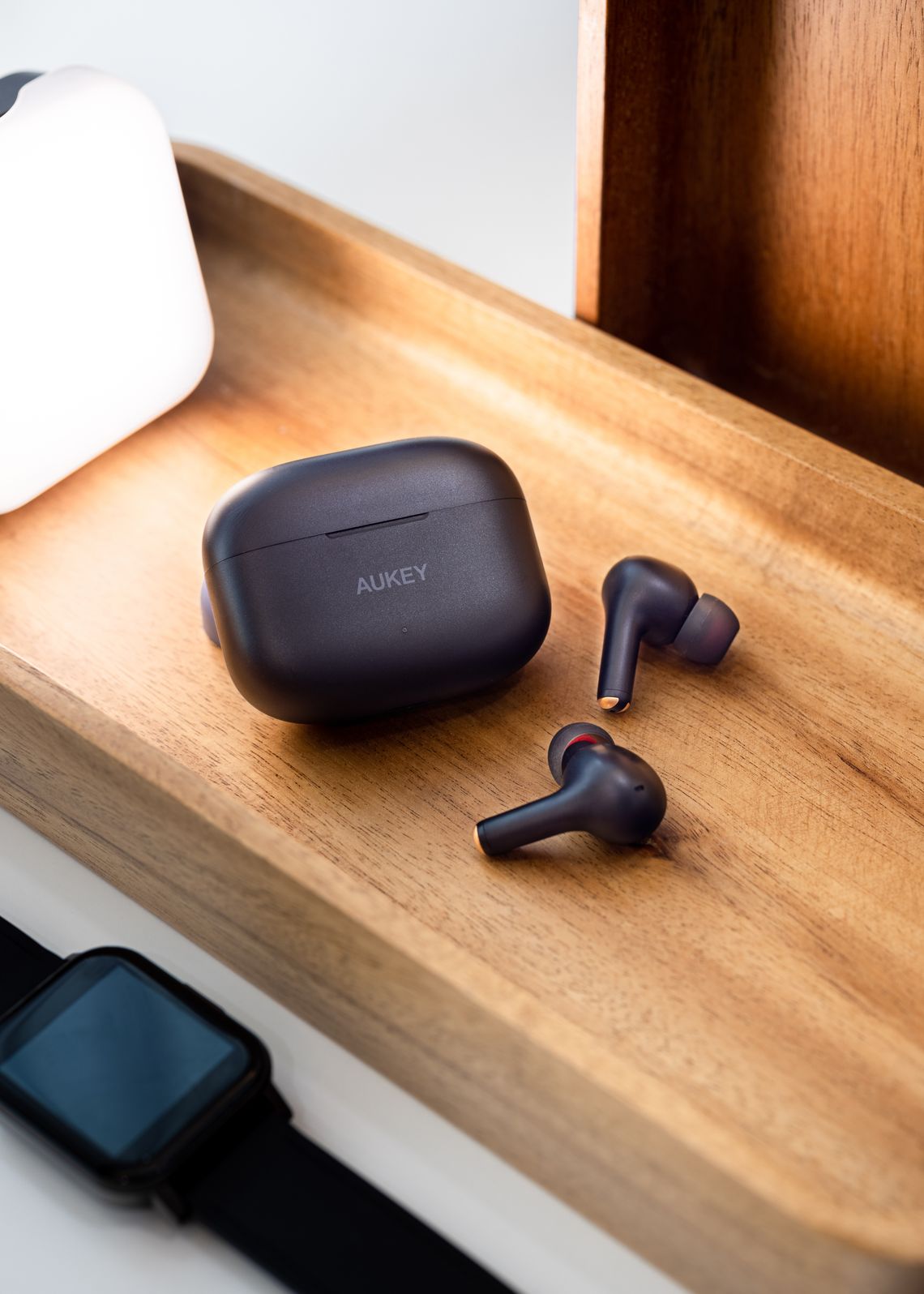 Wireless earbuds and smartwatch displayed in a premium technology setting