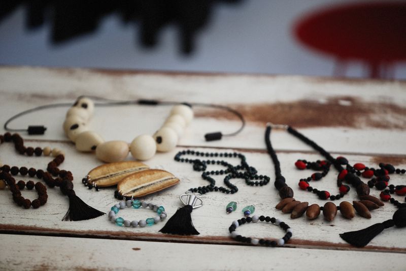 Collection of handmade beaded necklaces on a wooden table, reference style