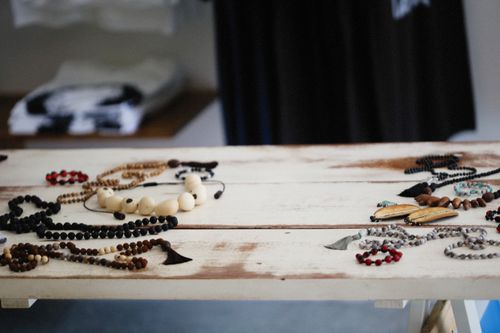 Free A diverse display of handcrafted wooden jewelry and beads on a rustic table indoors. Stock Photo