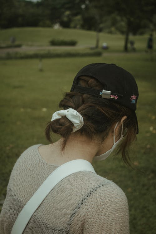 Brunette Woman in Park Wearing Cap and Face Mask