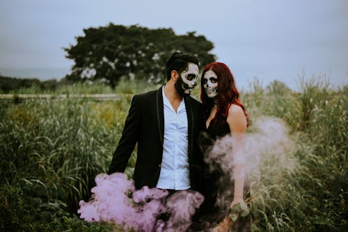 Free Couple with Face Paint Standing in the Field Stock Photo