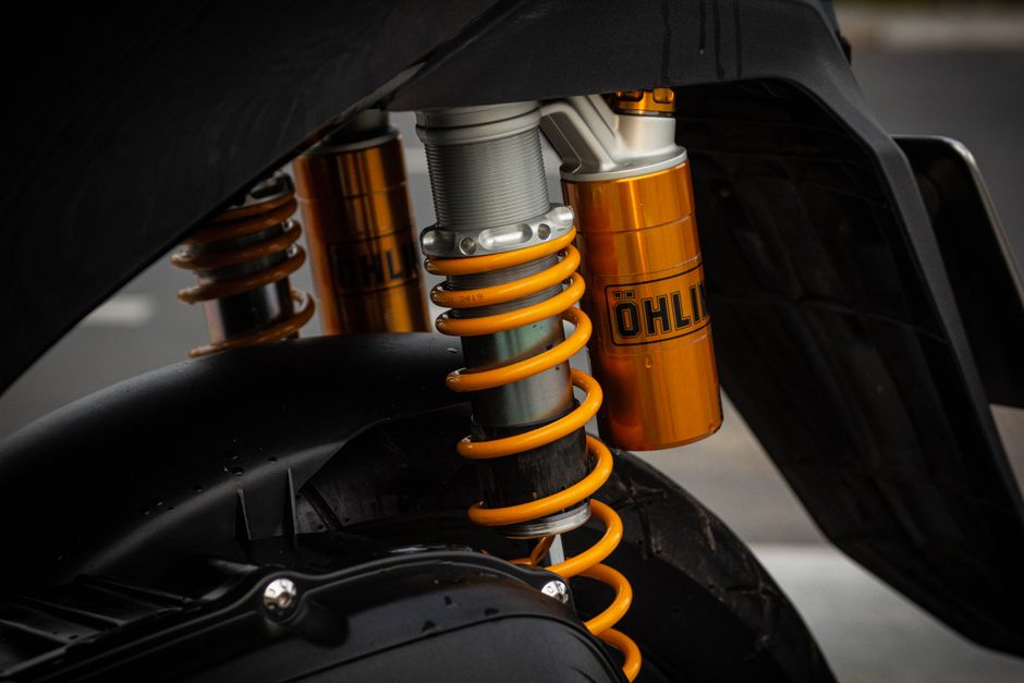 Detailed shot of a motorcycle suspension featuring Öhlins components for precision engineering focus.