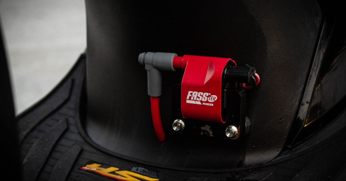 High-detail view of a red motorcycle coil on a black surface.