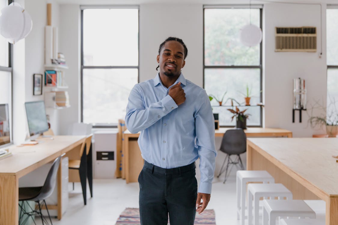 Free Man Standing and Making Gesture with Right Fist Touching Chest Stock Photo