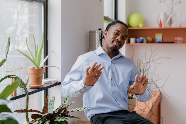 Portrait Of Businessman Showing Sign Language In Office