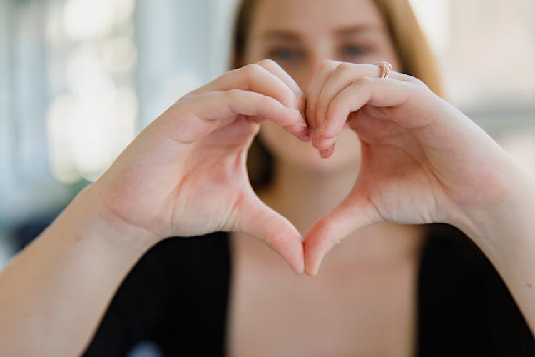 Close-up Of Woman Showing Heart Hand Sign