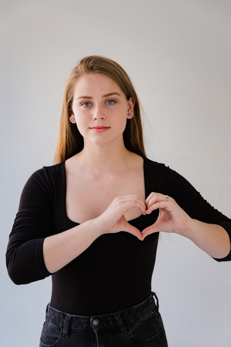 Woman Making Heart Gesture With Fingers Of Both Hands