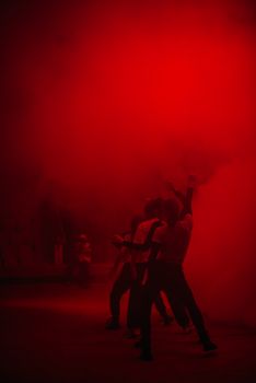 Group of protesters standing in vibrant red smoke, creating a powerful and dramatic scene.