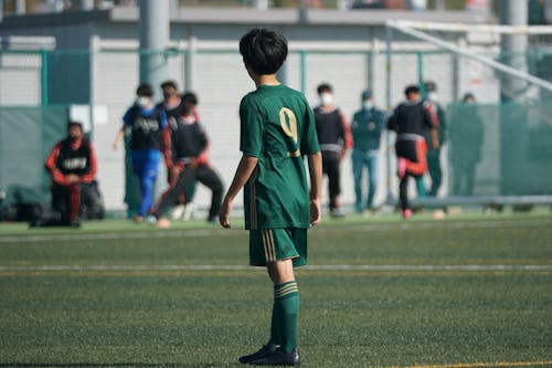 Free Person in Green Jersey Standing at the Field Stock Photo