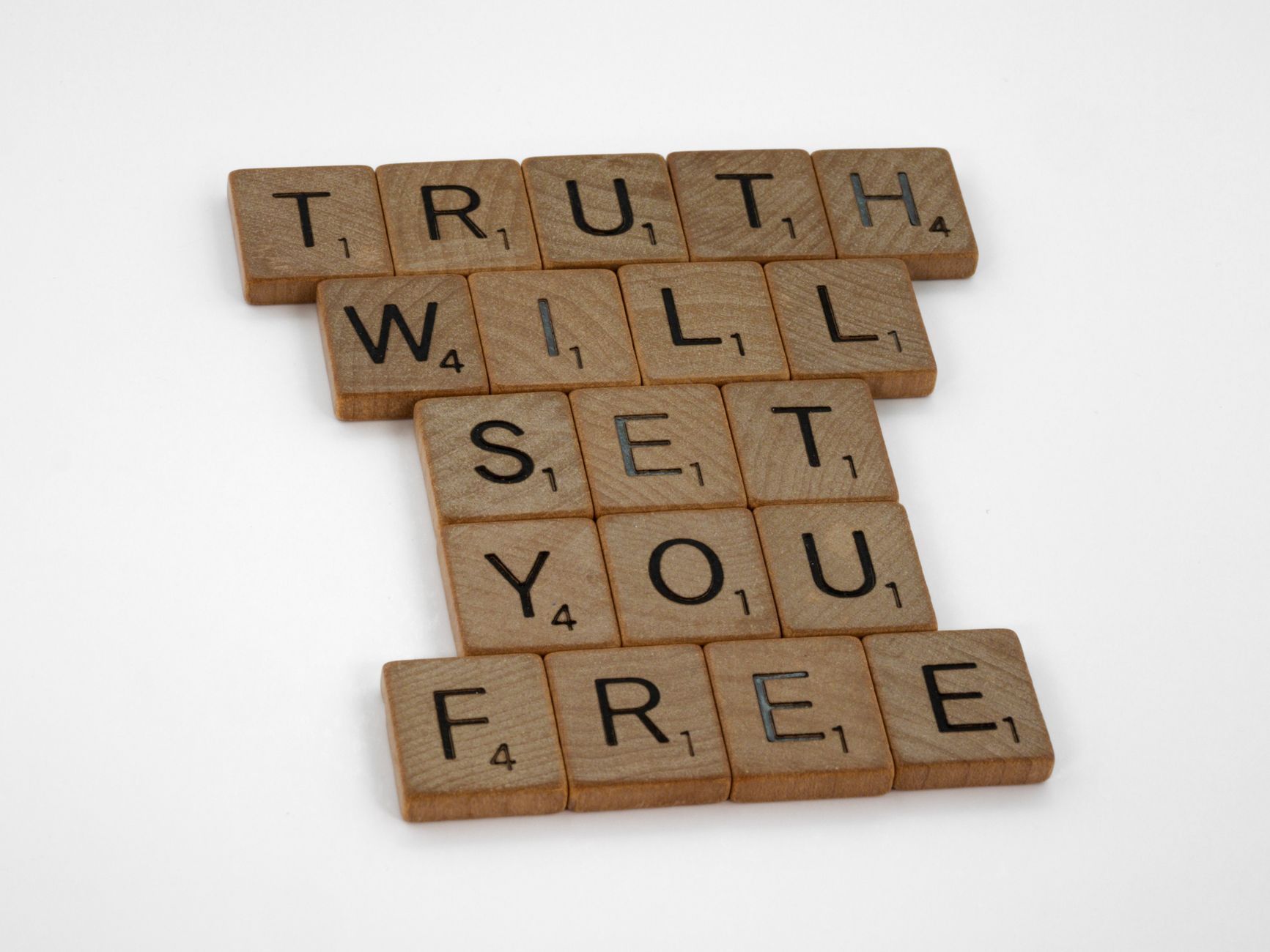 Scrabble tiles forming the phrase 'Truth Will Set You Free' on a white surface.