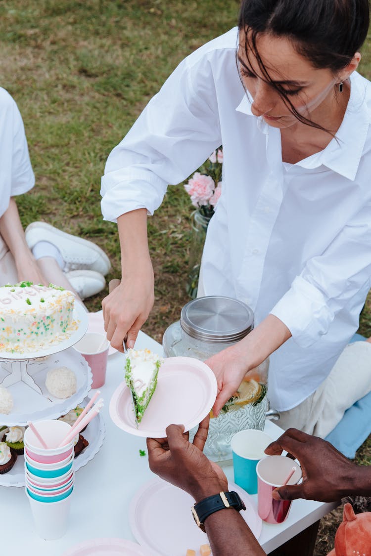 High Angle View Of Woman Serving Birthday Cake In Garden