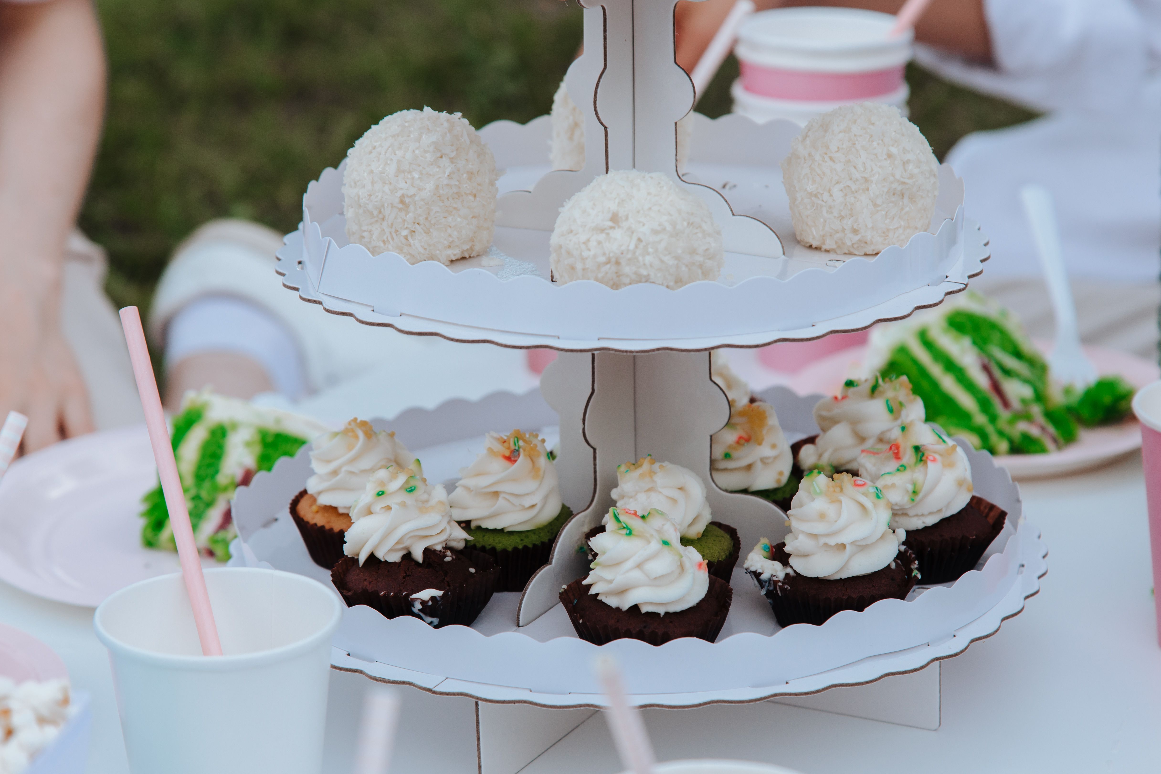 Enjoy a delightful garden party featuring cupcakes and treats on a stand.