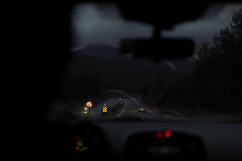 Vista de una autopista de noche desde el interior de un coche con los faros encendidos