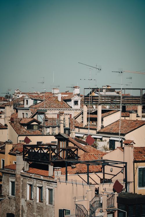 Free Aerial view capturing the charming rooftops of a town with antennas under clear sky. Stock Photo