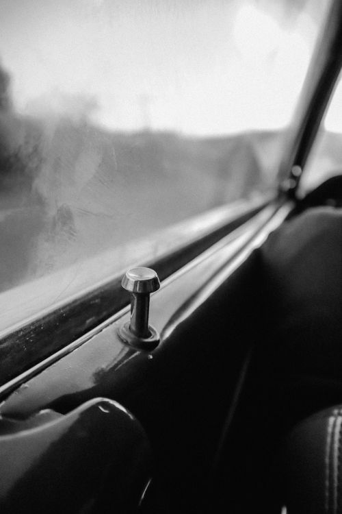 Free Close-up view of a vintage car window lock in a black-and-white style, capturing nostalgia. Stock Photo