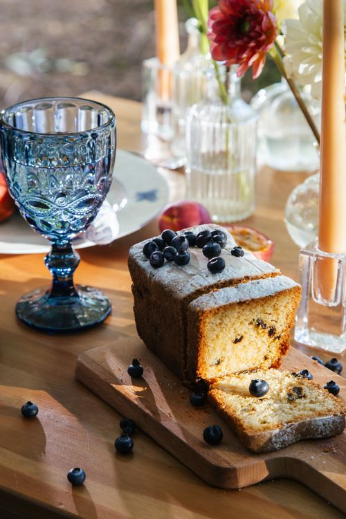 Free Sliced blueberry bread with decorative glassware on a wooden table, perfect for a rustic dining scene. Stock Photo