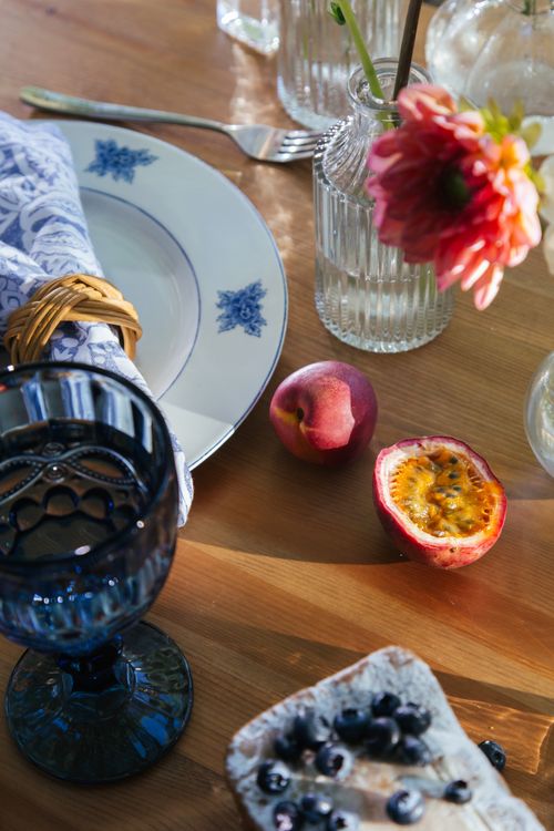 Free Close-up of a beautiful table setting with fruits and flowers creating a warm ambiance. Stock Photo