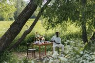 Man in White Dress Shirt Sitting on Brown Wooden Chair Under Tree