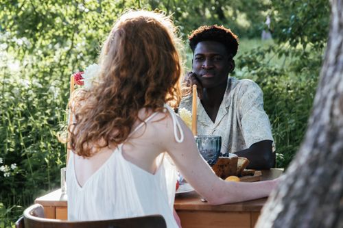 Free A young couple enjoys a romantic meal outdoors on a sunny summer day. Stock Photo