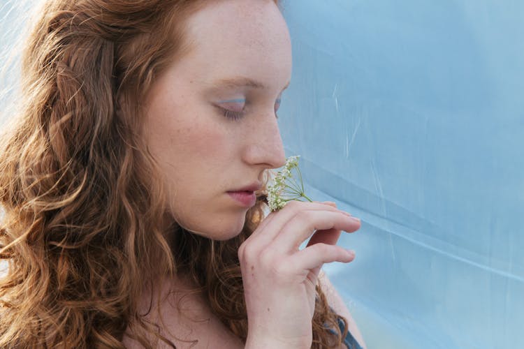 Close Up Photo Of A Woman Smelling Flowers