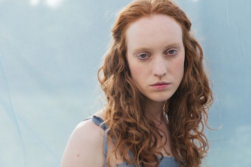 Free Soft focus portrait of a young woman with red hair against a light background. Stock Photo