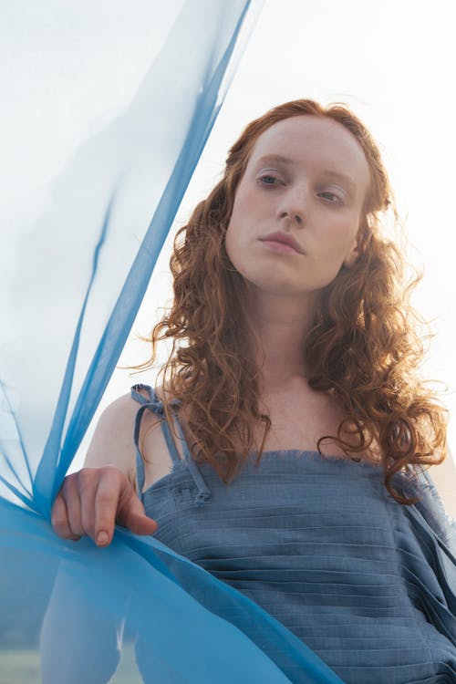 Young Woman Holding Blue Fabric Standing Outside 