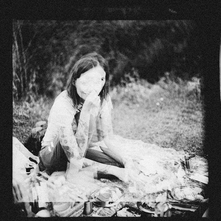 A Woman Sitting In A Meadow