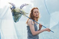 Woman Holding a Butterfly Net with Flowers
