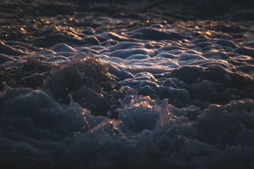 Free Close-up of ocean waves with sunlit foam during golden hour, showcasing natural beauty. Stock Photo