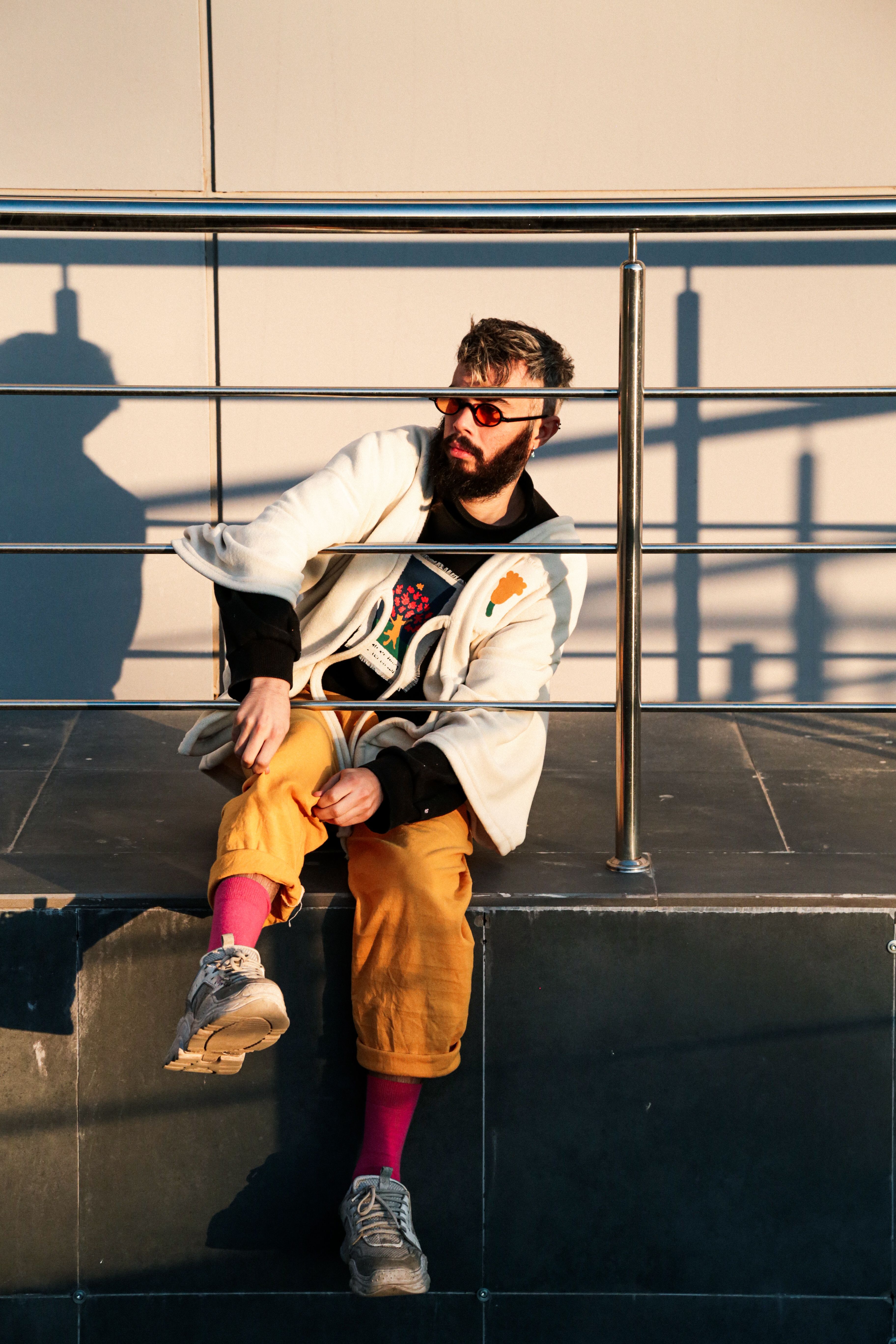 Portrait of a Man Sitting behind a Railing · Free Stock Photo