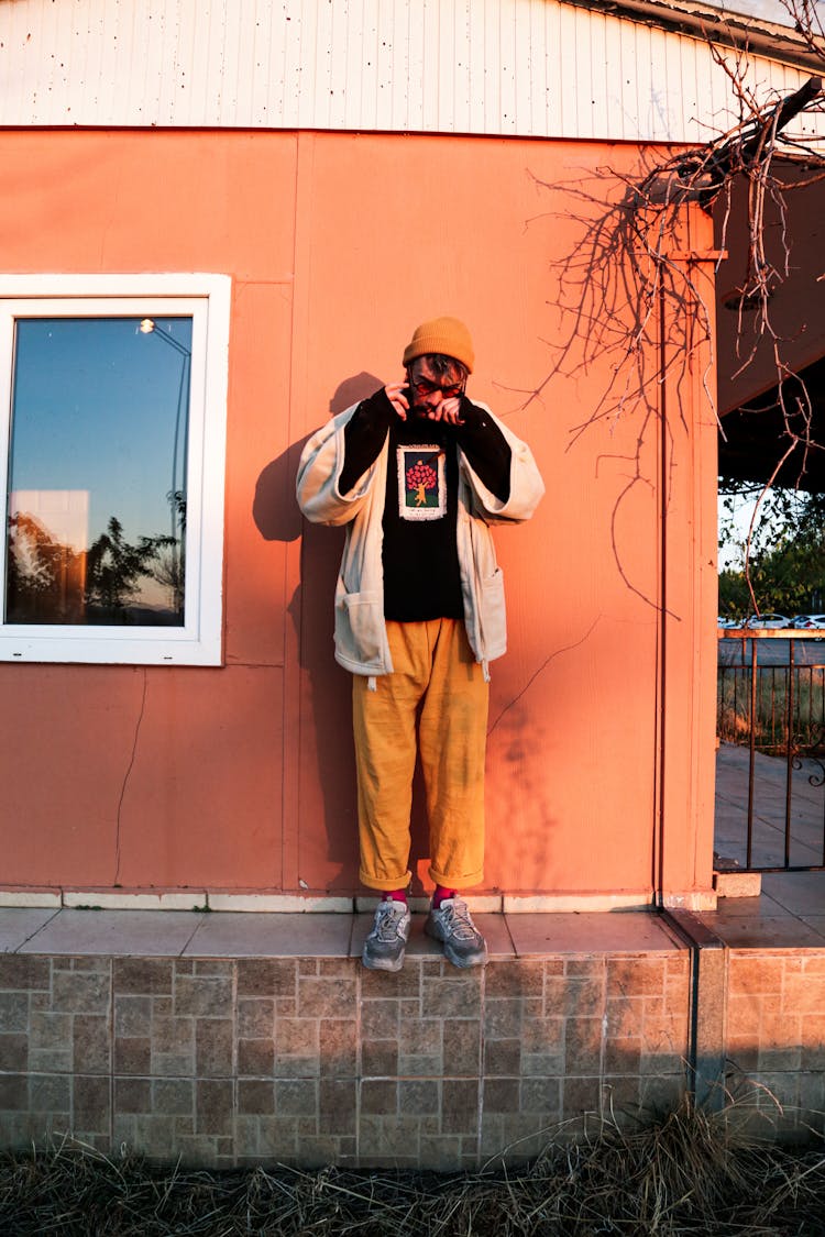 A Man Standing By A House