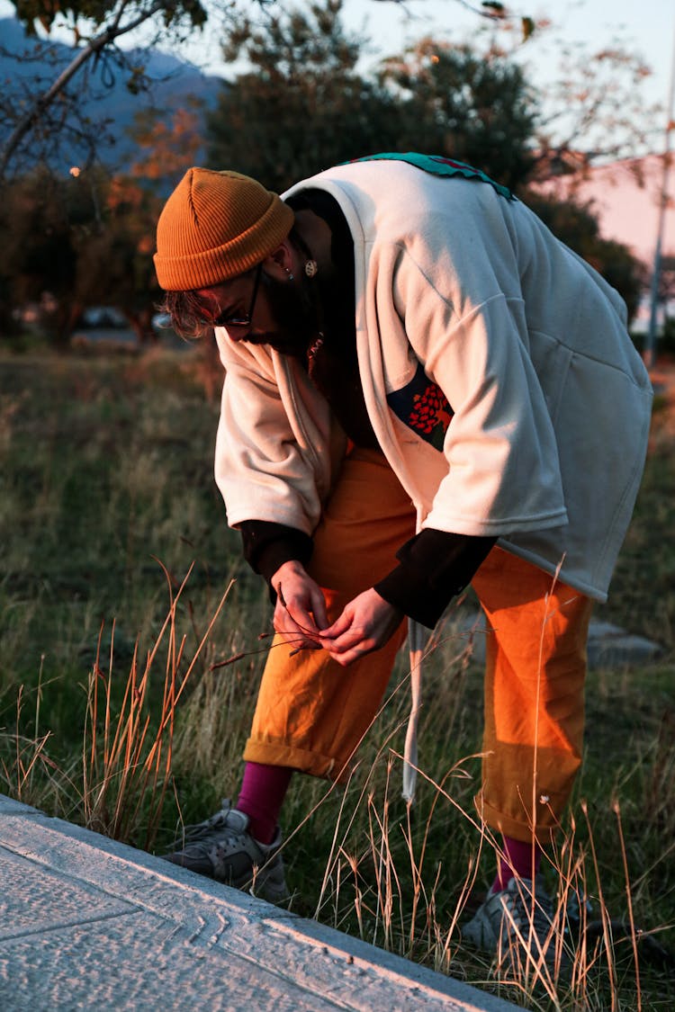 A Man Picking Grass Flowers From The Ground