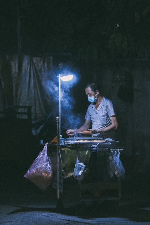 Street Vendor Selling from Stand at Night
