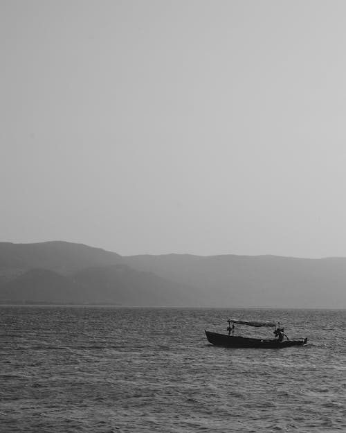 Black and White Photo of Fishing Boat on Water