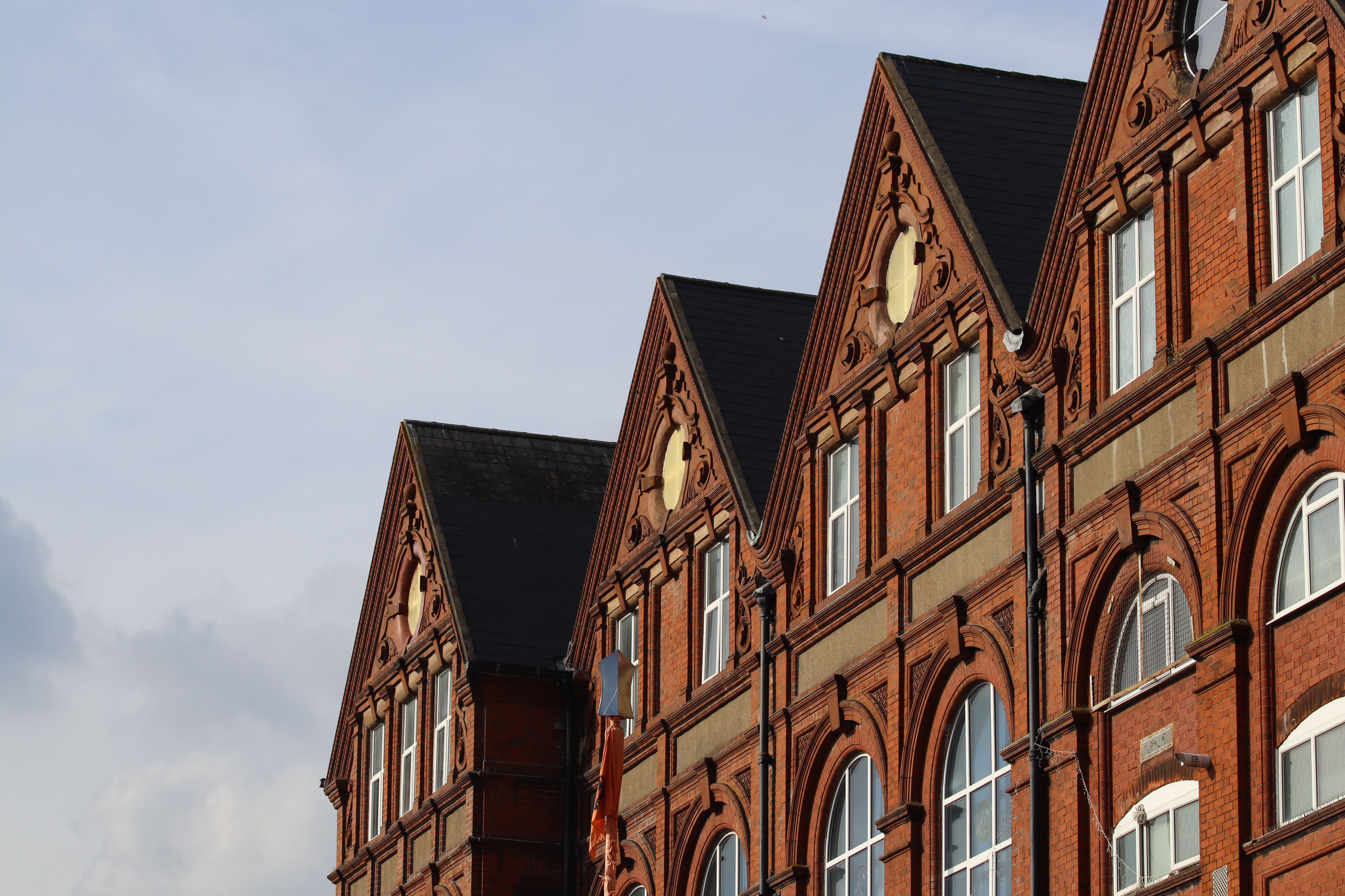 Low angle of a classic brick building showcasing intricate architecture under a clear sky.