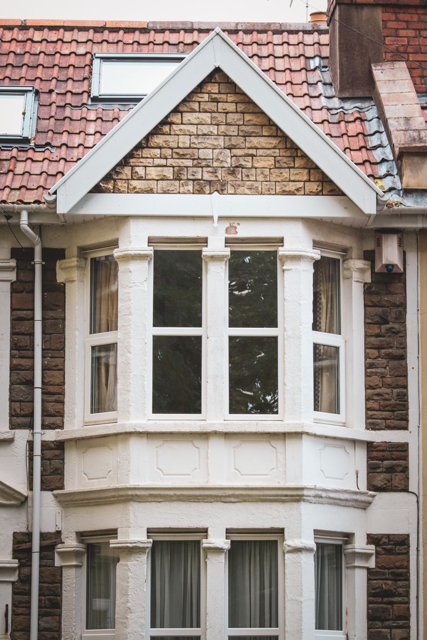 A white-framed bay window set into traditional British brickwork