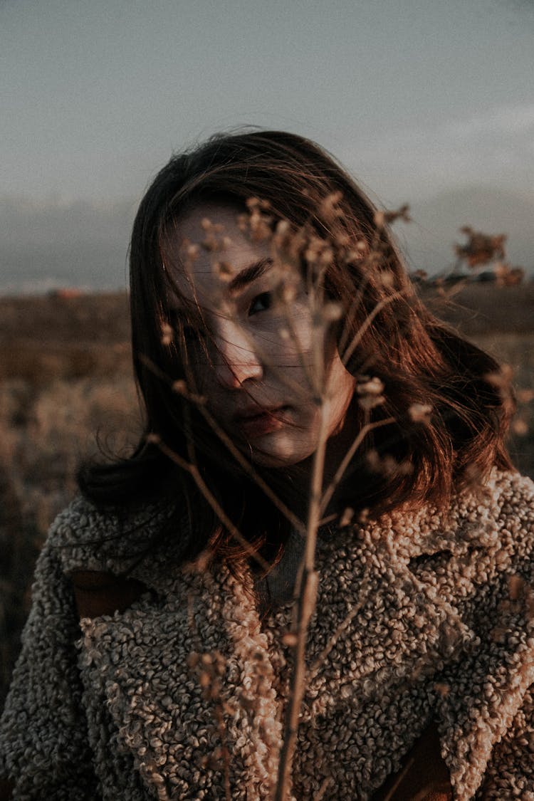 A Woman In Furry Coat Holding A Grass