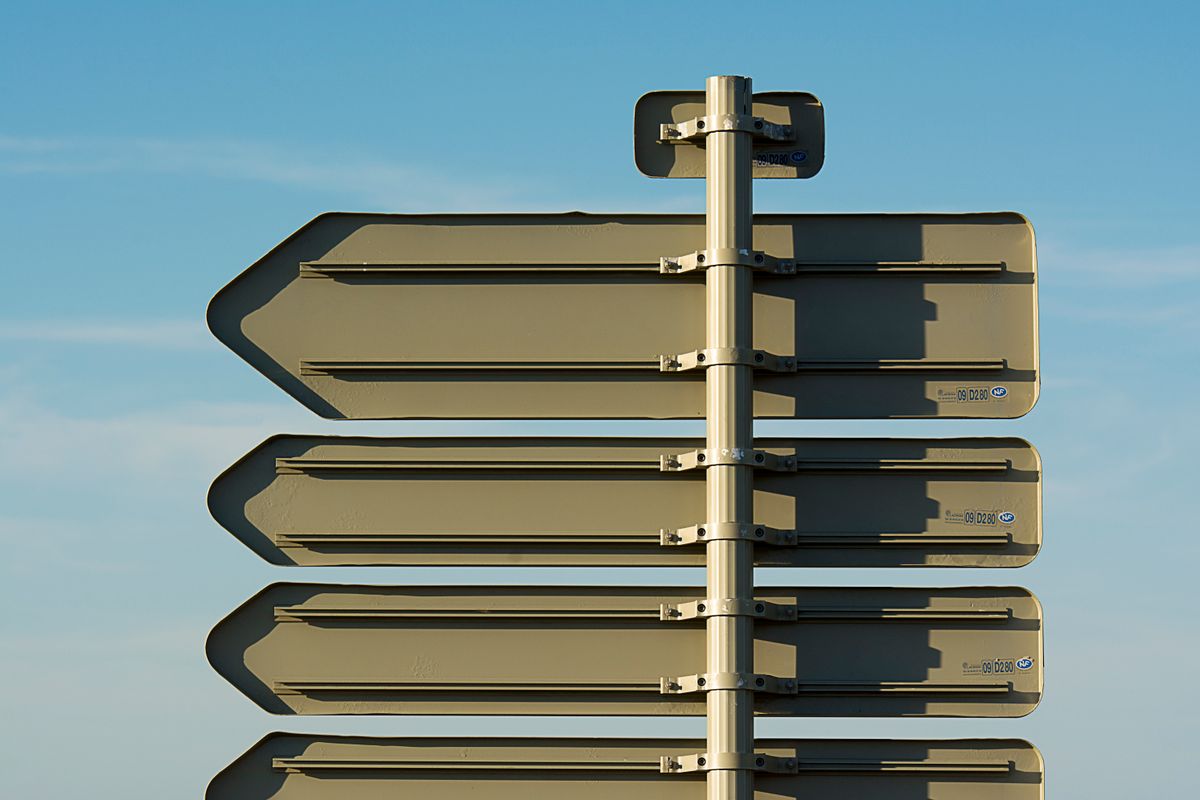 Blank directional signs against a clear sky. Photo by Jan van der Wolf on Pexels.