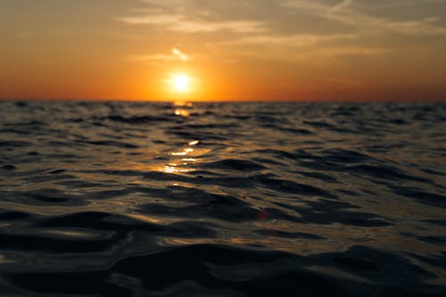 無料 水域とオレンジ色の夕日 写真素材