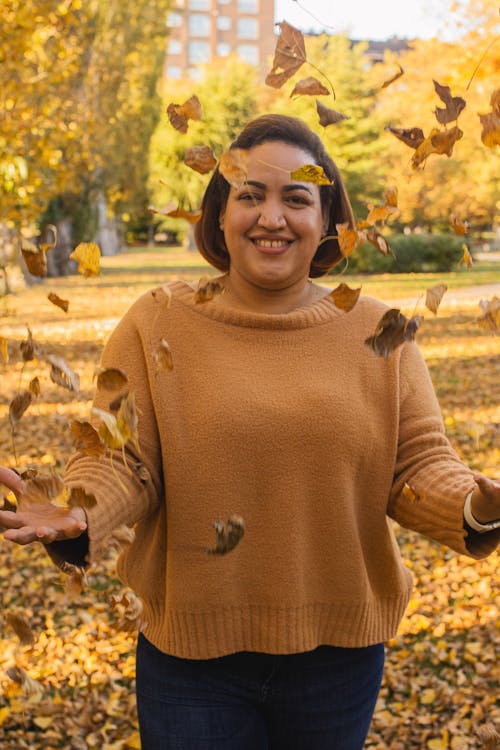 Free Woman Wearing Sweater Throwing Dry Leaves Stock Photo