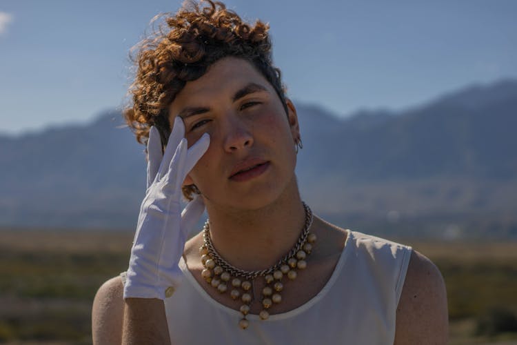 A Man Wearing White Gloves And Pearl Necklace