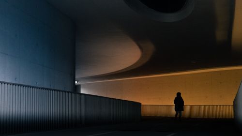 Free Silhouette of a person in a modern tunnel in Luxembourg with dramatic lighting and architecture. Stock Photo