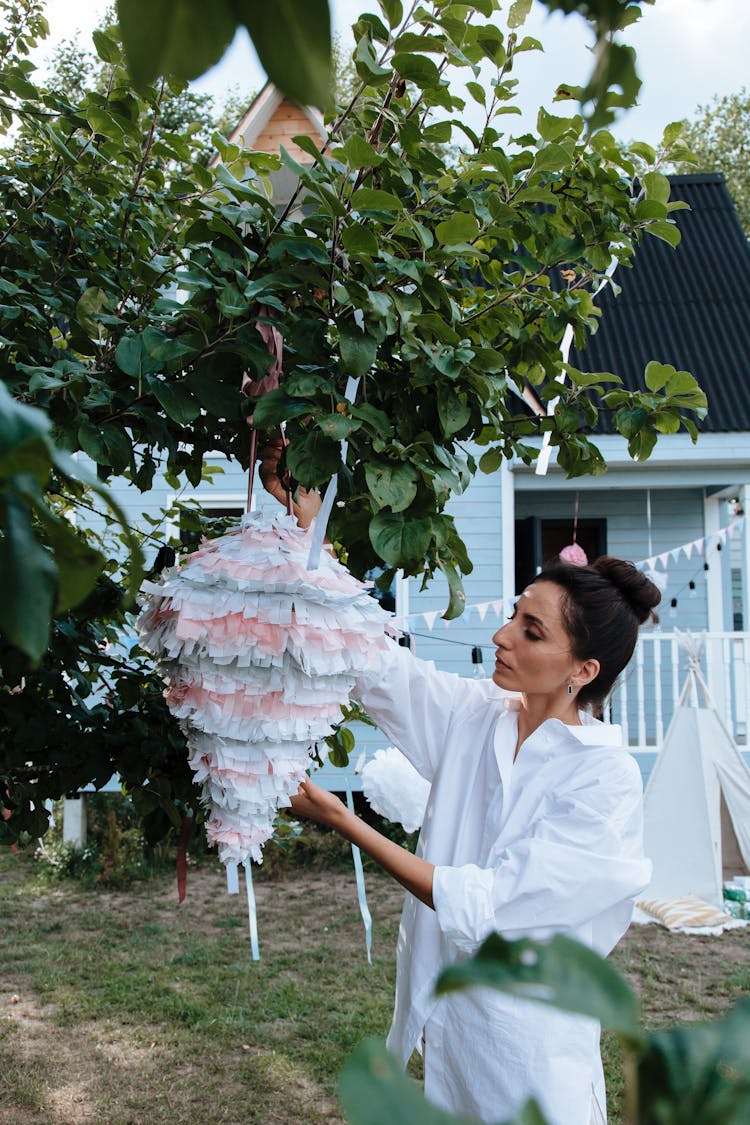 Woman Hanging Pinata On Tree