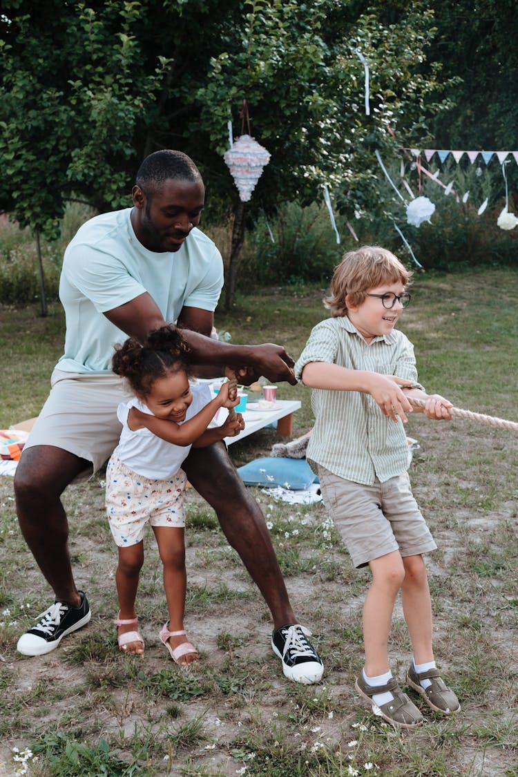 Dad And Kids Playing Tug Of War